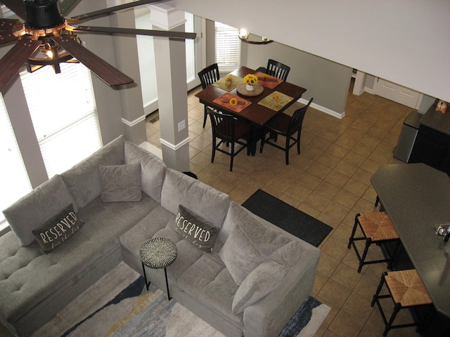 living room with a ceiling fan, baseboards, and tile patterned flooring