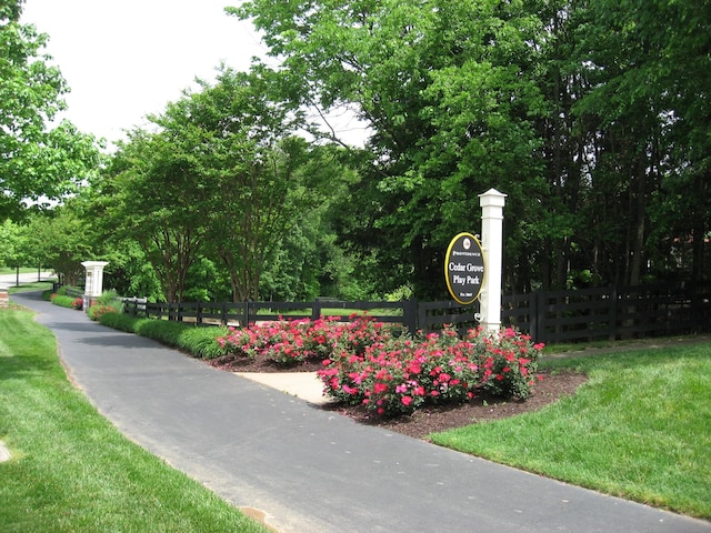 view of home's community featuring fence and a lawn