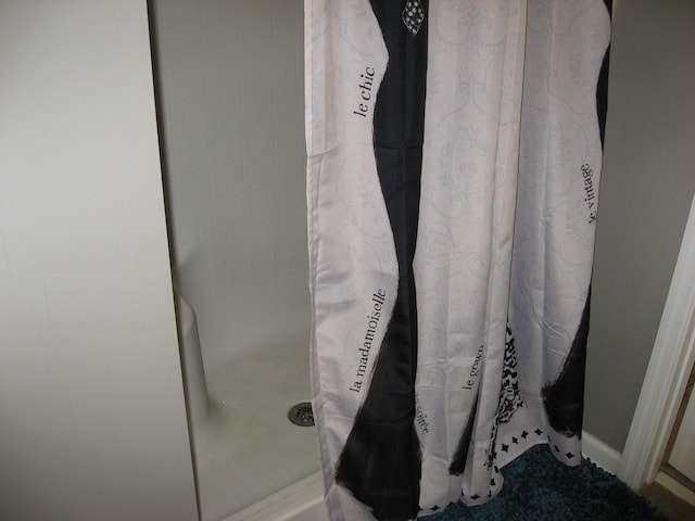 interior details featuring baseboards and curtained shower