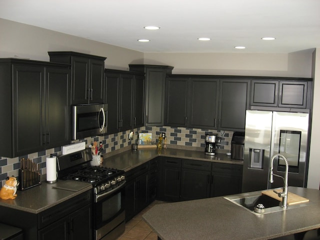 kitchen with dark cabinets, tasteful backsplash, and appliances with stainless steel finishes
