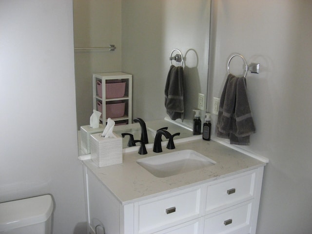 half bathroom with vanity and toilet