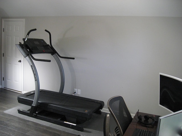 workout area featuring wood finished floors and baseboards