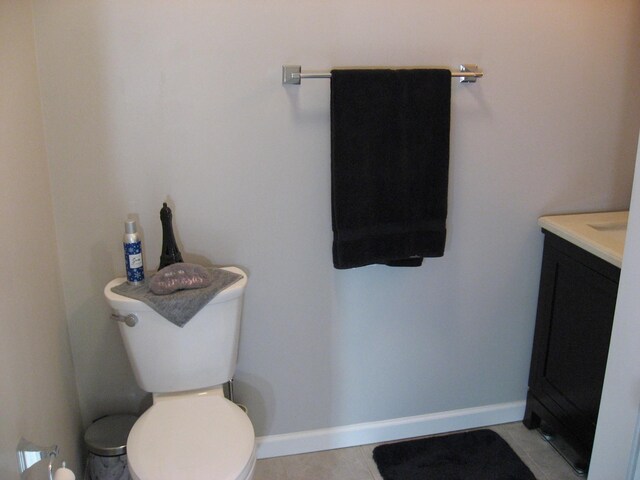 bathroom with vanity, toilet, tile patterned flooring, and baseboards