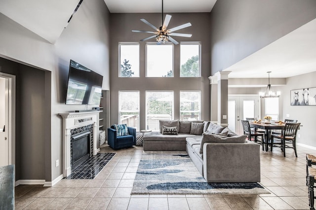 1505 Sylvan Park Ct, Mount Juliet, TN 37122 - living room featuring a tiled fireplace, a towering ceiling, ceiling fan, light tile patterned floors, and a chandelier