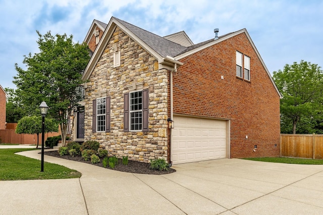 1505 Sylvan Park Ct, Mount Juliet, TN 37122 - view of side of property featuring fence, concrete driveway, stone siding, a garage, and brick siding