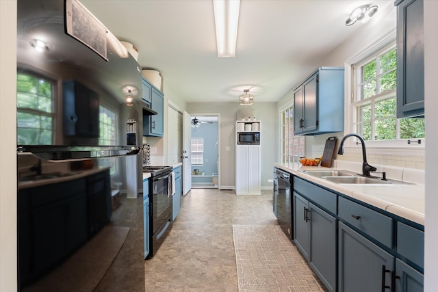 kitchen with a sink, light countertops, baseboards, backsplash, and black appliances