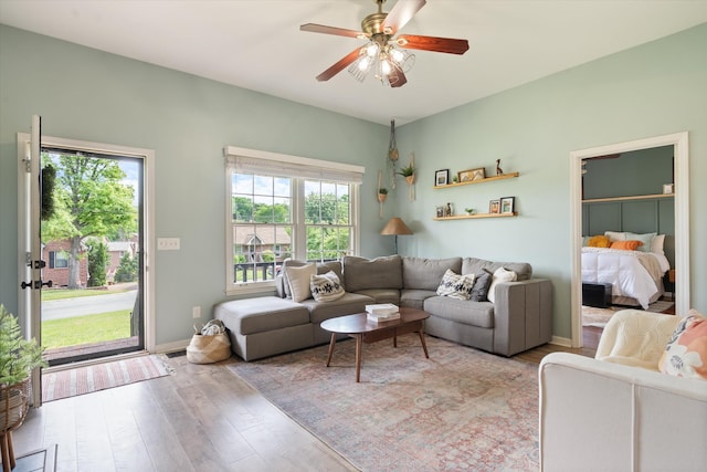 living room featuring a ceiling fan and light wood-style flooring