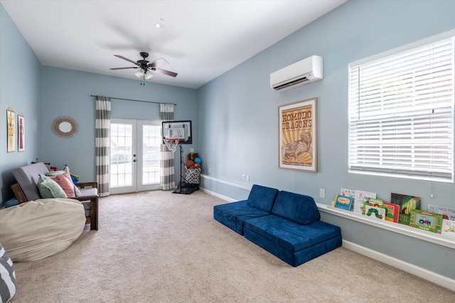 living area featuring a ceiling fan, french doors, a wall mounted AC, carpet floors, and baseboards