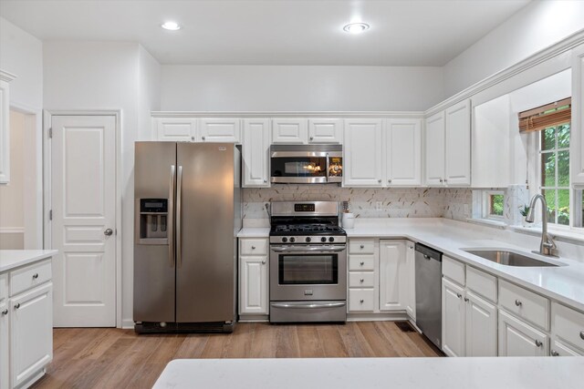 1069 Fitzpatrick Rd, Nashville, TN 37214 - kitchen featuring stainless steel appliances, a sink, white cabinetry, tasteful backsplash, and light countertops