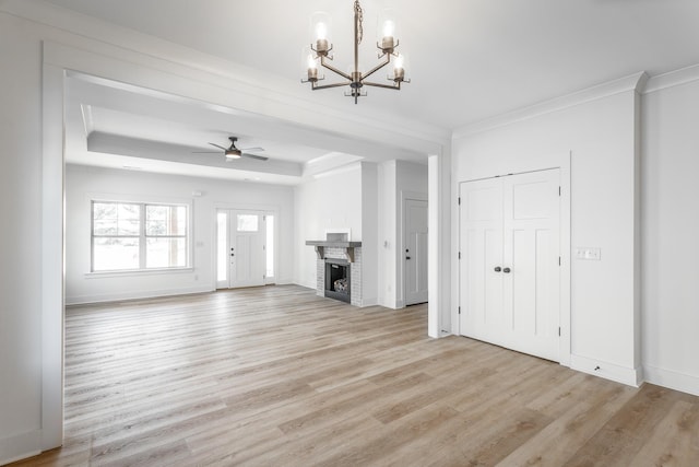 492 Willow Grove Ct Unit 60, Ringgold, GA 30736 - unfurnished living room with ornamental molding, a brick fireplace, a tray ceiling, light wood-style flooring, and ceiling fan with notable chandelier