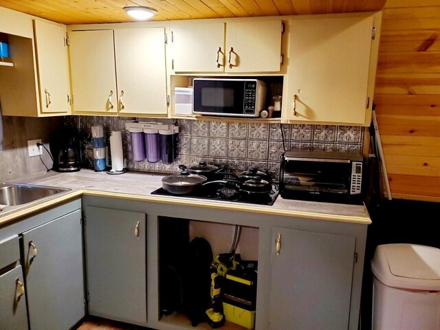 4179 Beaver Bend Dr, Nunnelly, TN 37137 - kitchen with light countertops, gray cabinets, black stovetop, backsplash, and wood ceiling