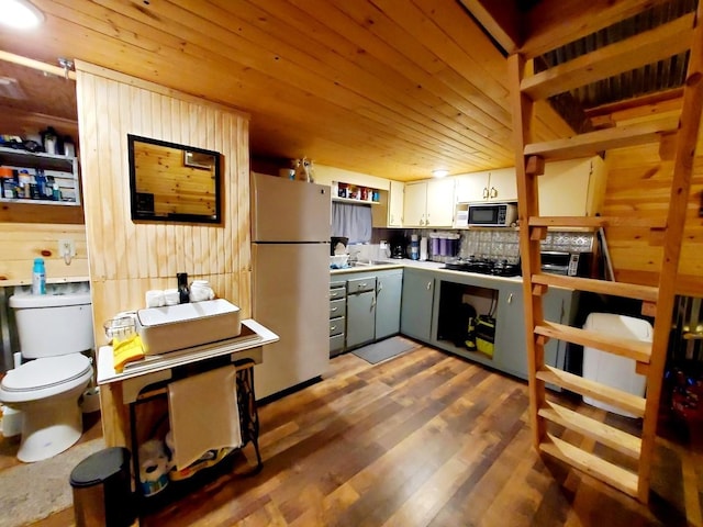 4179 Beaver Bend Dr, Nunnelly, TN 37137 - kitchen with wood walls, wood finished floors, a sink, wooden ceiling, and freestanding refrigerator