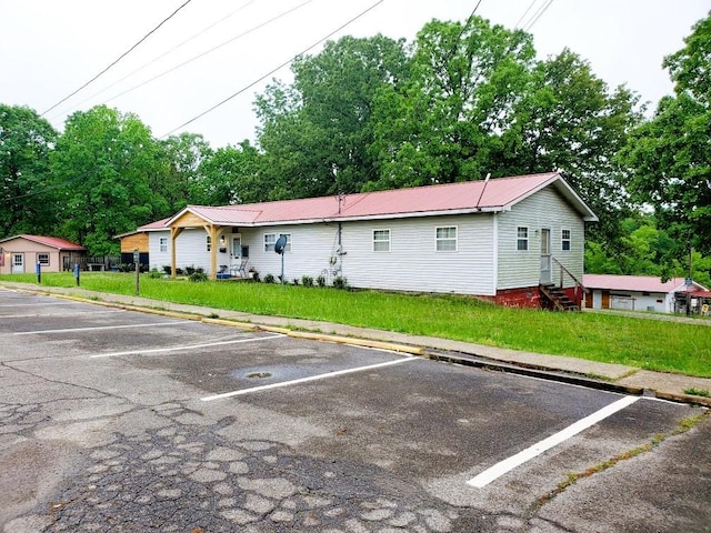 4179 Beaver Bend Dr, Nunnelly, TN 37137 - exterior space with uncovered parking, metal roof, a front yard, and entry steps