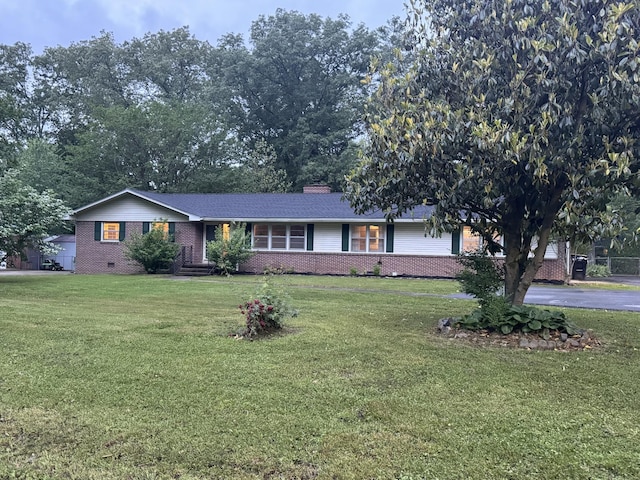 ranch-style home featuring brick siding and a front lawn