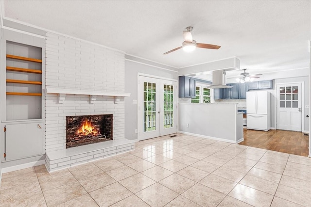 419 Westwood Dr, Tullahoma, TN 37388 - unfurnished living room with a ceiling fan, light tile patterned floors, crown molding, a brick fireplace, and french doors