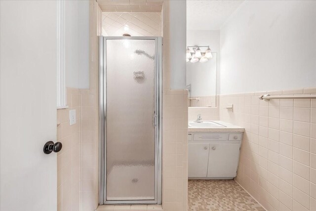 419 Westwood Dr, Tullahoma, TN 37388 - full bathroom featuring tile walls, a shower stall, vanity, and wainscoting
