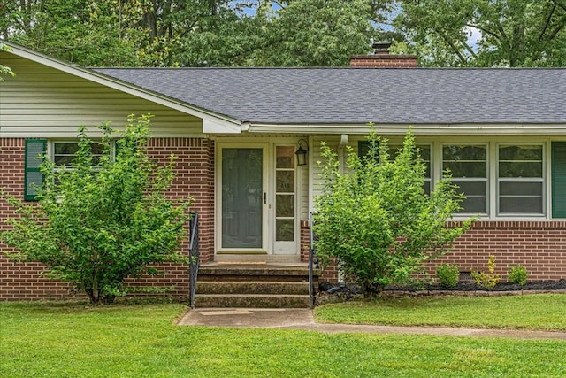 419 Westwood Dr, Tullahoma, TN 37388 - property entrance with brick siding, a shingled roof, a chimney, and a yard