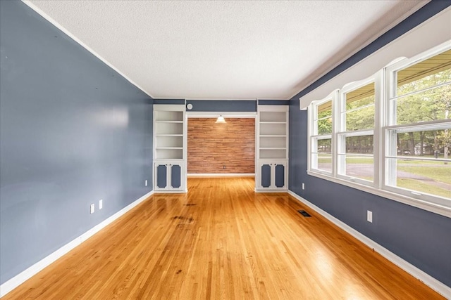 419 Westwood Dr, Tullahoma, TN 37388 - empty room featuring wood finished floors, built in features, a textured ceiling, and baseboards