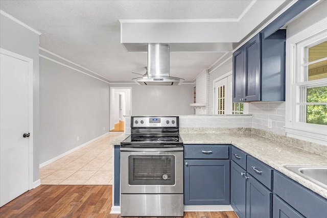 419 Westwood Dr, Tullahoma, TN 37388 - kitchen with stainless steel electric stove, island exhaust hood, a peninsula, light countertops, and light wood-style floors