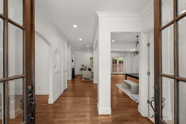 hall featuring french doors, baseboards, dark wood-style floors, a chandelier, and ornamental molding