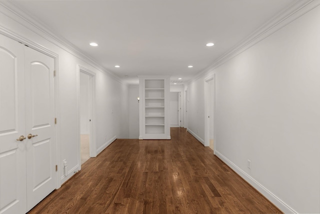 hall featuring crown molding, built in features, baseboards, recessed lighting, and dark wood finished floors