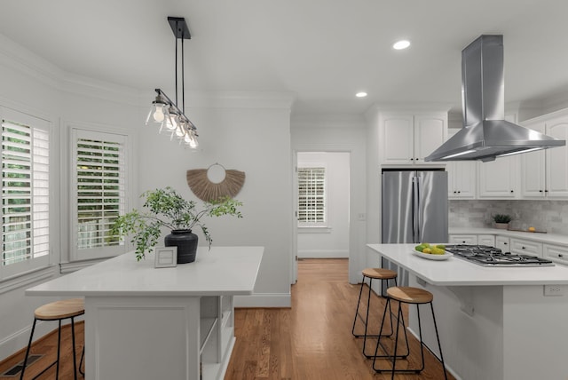 kitchen featuring a kitchen island, a kitchen breakfast bar, appliances with stainless steel finishes, and island range hood