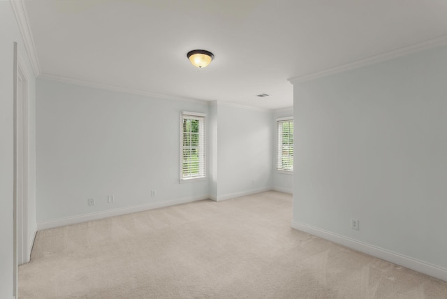 empty room featuring crown molding, baseboards, and light carpet