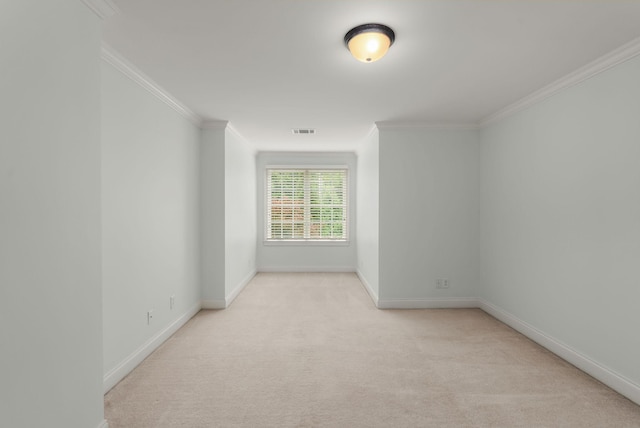 empty room featuring baseboards, ornamental molding, light carpet, and visible vents