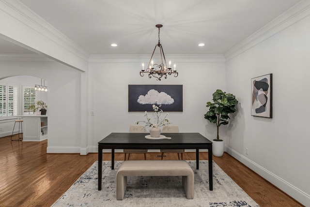 dining room featuring an inviting chandelier, baseboards, ornamental molding, and wood finished floors