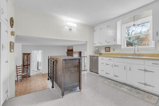 kitchen featuring a sink, a textured ceiling, dishwasher, white cabinetry, and light countertops