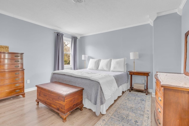 bedroom with crown molding, a textured ceiling, baseboards, and light wood-type flooring