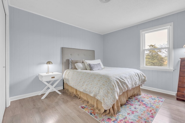 bedroom featuring crown molding, baseboards, and light wood-type flooring