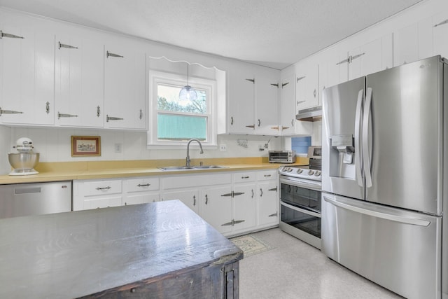 kitchen featuring a sink, under cabinet range hood, light countertops, white cabinets, and appliances with stainless steel finishes
