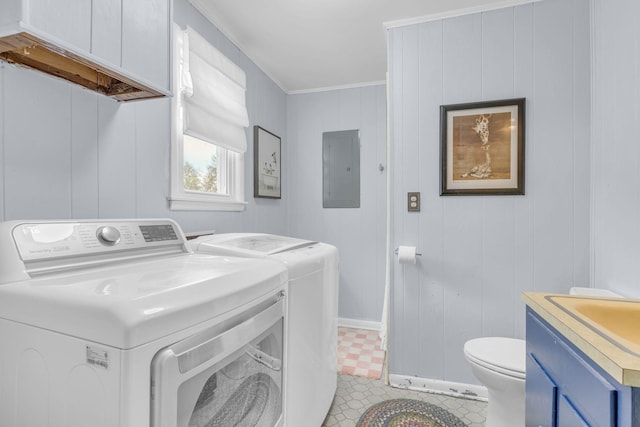 washroom featuring ornamental molding, a sink, electric panel, washing machine and clothes dryer, and laundry area