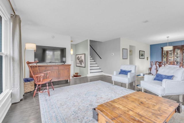 living area featuring stairway, baseboards, and wood finished floors