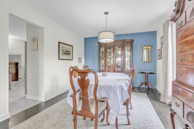 dining space featuring baseboards and wood finished floors