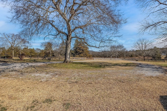 view of yard featuring fence and a rural view