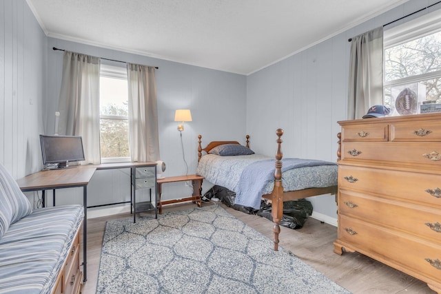 bedroom with ornamental molding and light wood-type flooring