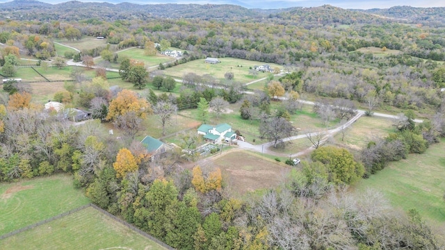 birds eye view of property featuring a rural view, a view of trees, and a mountain view
