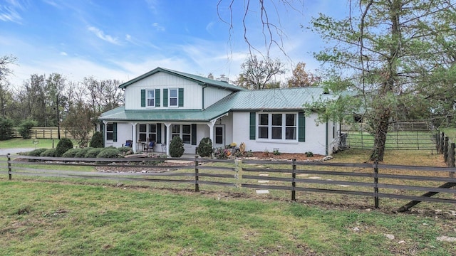 traditional-style house featuring covered porch, metal roof, fence private yard, a front lawn, and a chimney