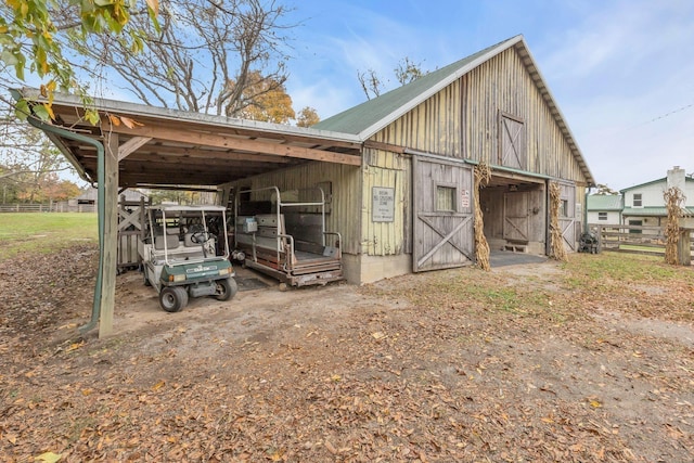 view of barn featuring fence