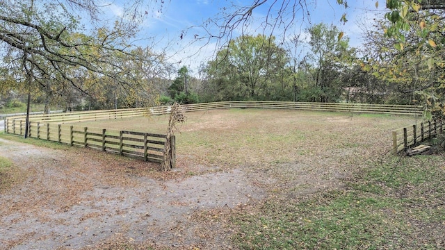 view of yard with fence and a rural view