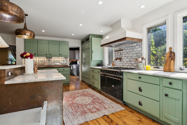 503 Brick Church Pike, Goodlettsville, TN 37072 - kitchen with high end stove, green cabinetry, light wood-type flooring, premium range hood, and tasteful backsplash