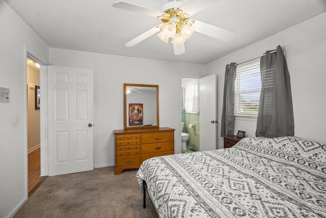 carpeted bedroom featuring a ceiling fan, baseboards, and ensuite bath