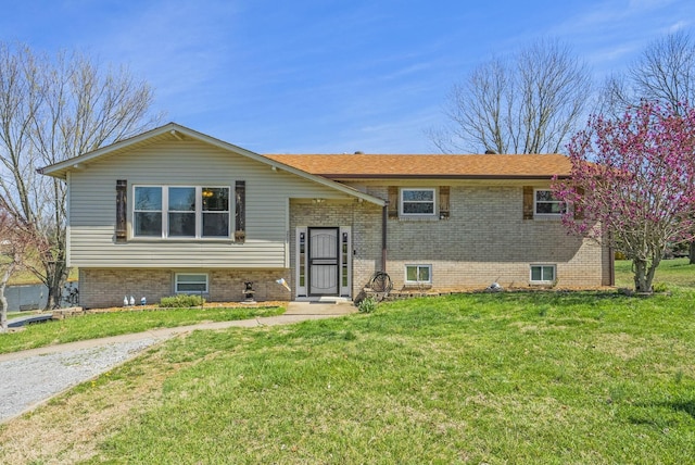 split foyer home featuring brick siding and a front lawn