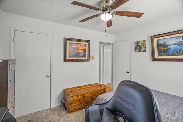 office area with a textured ceiling, carpet, and a ceiling fan
