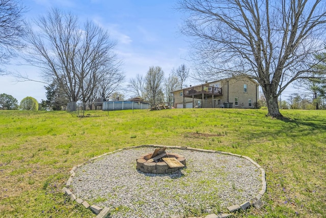 view of yard featuring a wooden deck and a fire pit