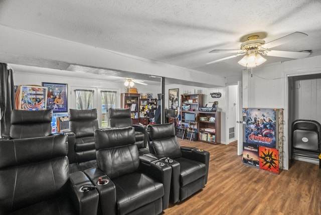 home theater room with a textured ceiling, a ceiling fan, and wood finished floors