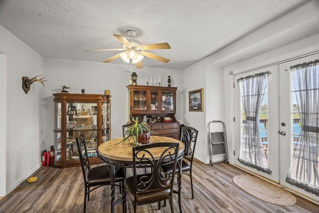 dining area featuring a ceiling fan, a textured ceiling, wood finished floors, and baseboards