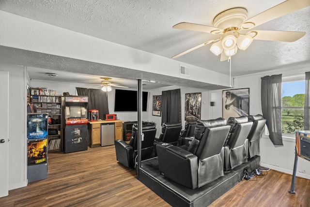 interior space with a textured ceiling, visible vents, wood finished floors, and a ceiling fan